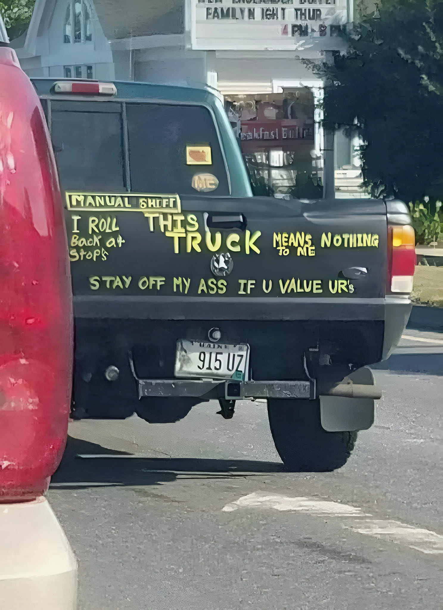 The image is of a truck with a humorous and somewhat threatening message written on the back. The message reads: "I ROLL BACK AT STOP'S. THIS TRUCK MEANS NOTHING TO ME. STAY OFF MY ASS IF YOU VALUE YOURS." The message is written in a childish, handwritten style, with some of the words and letters misspelled or intentionally misspelled for effect.